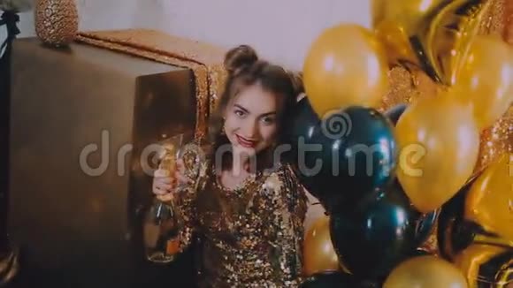 穿着金色连衣裙和马提尼酒杯的年轻女孩视频的预览图