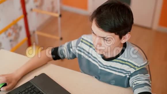 那少年正坐在桌旁用笔记本电脑视频的预览图