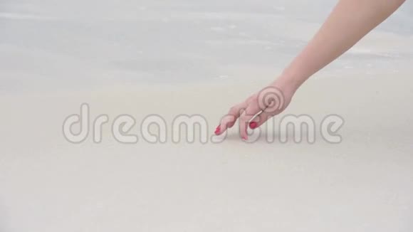 女人用手在沙滩上画心脏符号用水把它洗掉视频的预览图