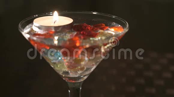在玻璃中燃烧蜡烛散落的宝石奉献双手和双心视频的预览图