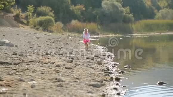 小可爱的女孩沿着湖边跑视频的预览图