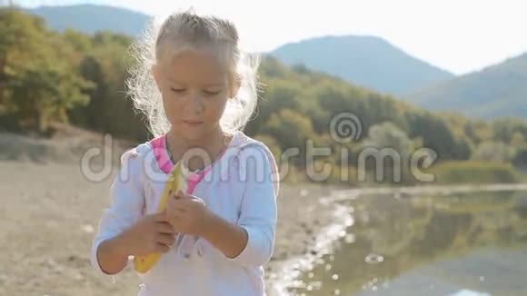 小金发女孩吃香蕉的肖像视频的预览图