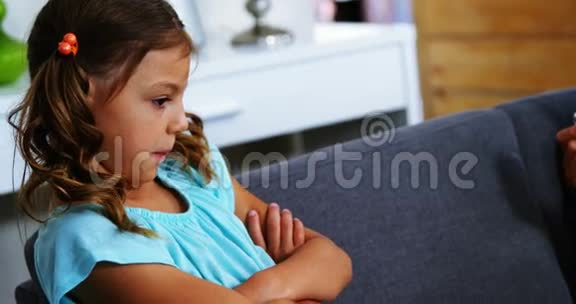 坐在客厅里双臂交叉的悲伤女孩视频的预览图