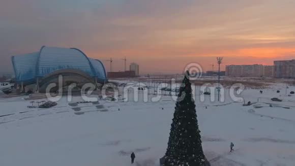 在日落时分用一棵圣诞树飞过城市的中心地带视频的预览图