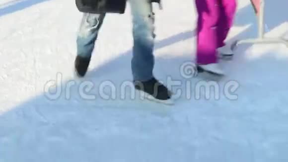 在阳光明媚的冬日人们在溜冰场上溜冰视频的预览图