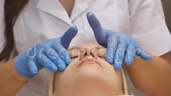 美容师在病人的皮肤上涂霜视频的预览图