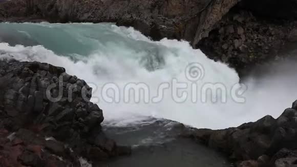 强大的汹涌的白水瀑布有力地落在岩石边缘水晶般清澈的冰川水流在cl上落下视频的预览图