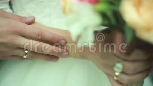 新郎的手抚摸新娘结婚戒指视频的预览图