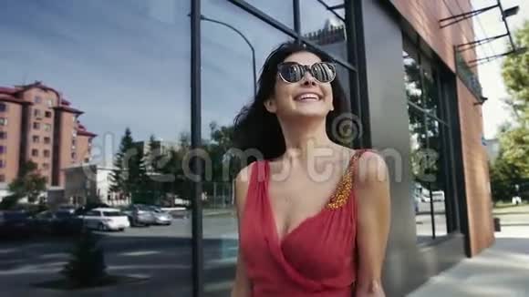 迷人的微笑女人走在街上之后慢动作视频的预览图