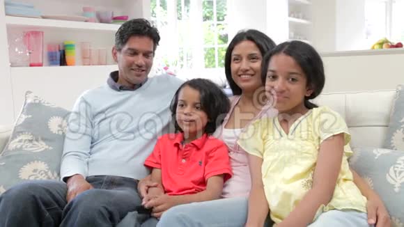印度家庭一起坐沙发看电视视频的预览图