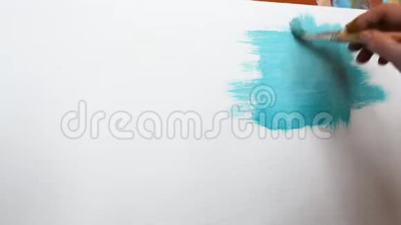 艺术家用蓝色油画颜料在白色画布上作画视频的预览图