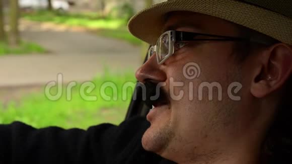 戴着胡子戴着帽子的人戴着眼镜坐在车里唱歌夏日仿造视频的预览图