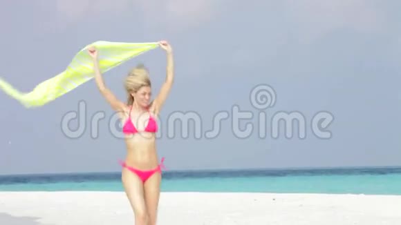 在美丽的沙滩上和莎莉奔跑的比基尼女人视频的预览图