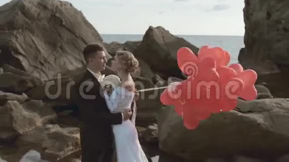 美丽的新婚夫妇拿着气球站着视频的预览图
