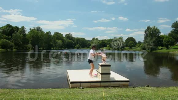 父亲在法国湖边的浮台上和女儿玩耍视频的预览图