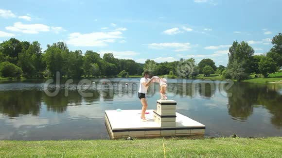 父亲在法国湖边的浮台上和女儿玩耍视频的预览图