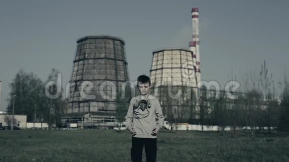 穿着防毒面具的男孩对着工厂烟囱空气污染概念视频的预览图