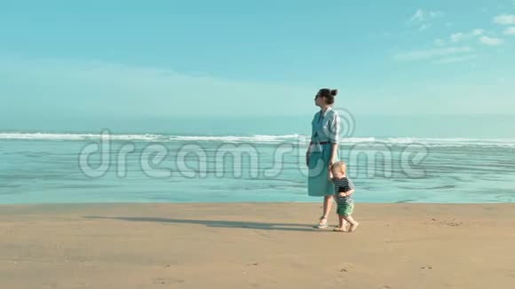 年轻漂亮的母亲和她美丽的小儿子在大西洋的早晨海滩上度过时光视频的预览图