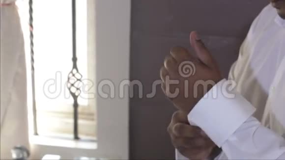 男人扣上白色结婚衫袖口和袖扣视频的预览图