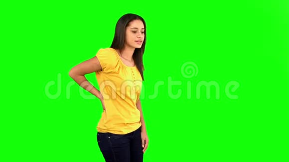 女人在绿色的屏幕上摩擦着痛苦的背视频的预览图