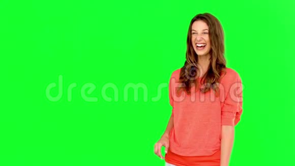 微笑的女人在绿色的屏幕上接住篮子球视频的预览图