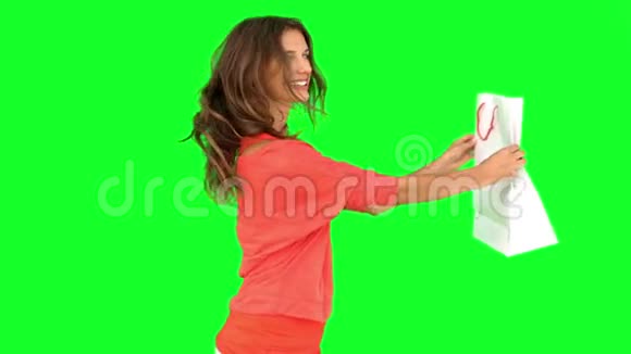 女人一边旋转一边在绿色屏幕上展示购物袋视频的预览图