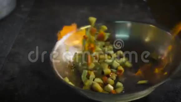 厨师煎蔬菜白兰地在锅里被点燃厨房里有明火视频的预览图