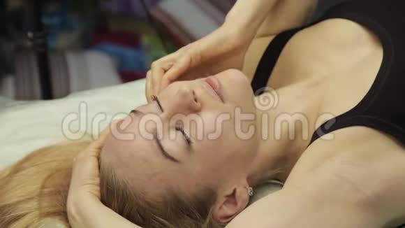 金发女人做自我按摩面部按摩躺在家里的床上视频的预览图