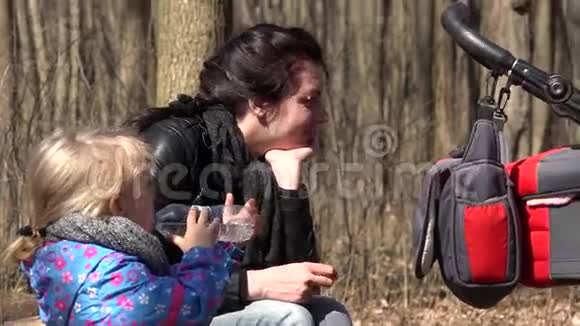 可爱的女孩和妈妈一起在森林里跑喝一杯水4K超高清超高清视频的预览图