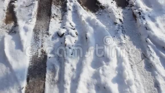 雪中的脚印和脚印雪中覆盖的城市街道视频的预览图