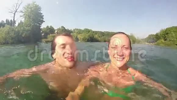年轻人和女孩微笑着潜入水中和水里视频的预览图