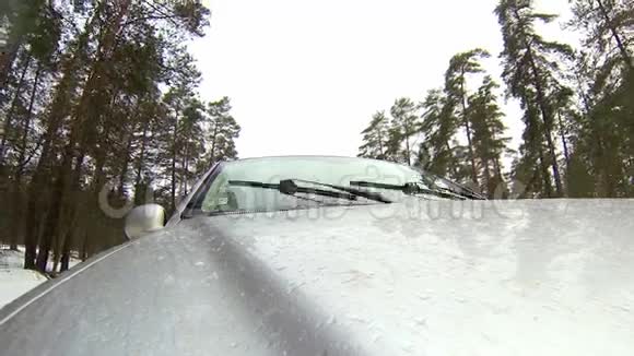在森林的冬季道路上行驶时摄像机安装在汽车上它会变成雪视频的预览图