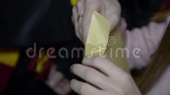 女士双手打开黄色信封把一张纸和文字递给男人视频的预览图