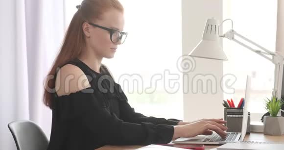 女商人在办公室工作时用手机说话视频的预览图