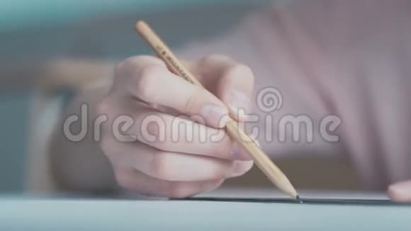 一个穿粉色上衣的女孩在画铅笔视频的预览图