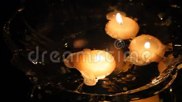 旧夜玻璃花瓶里漂浮的蜡烛冷静和放松浪漫和爱镜表面的反射冰烟雾视频的预览图