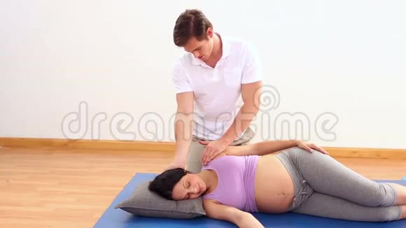 理疗师按摩他怀孕的病人的脖子视频的预览图