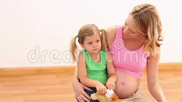 金发孕妇和她的小女孩坐在一起视频的预览图