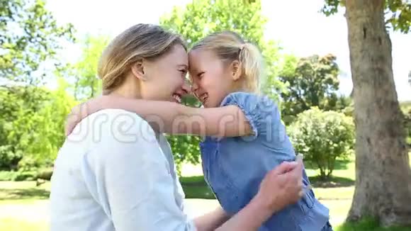 快乐的小女孩在公园里告诉她妈妈一个秘密视频的预览图