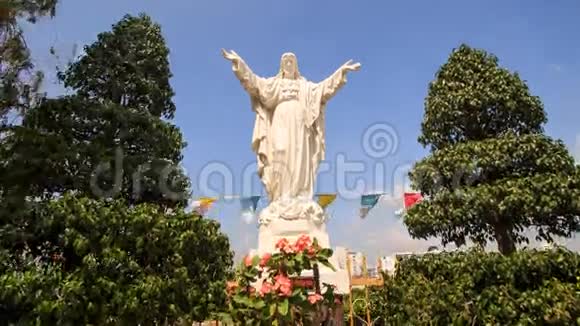 天主教教堂附近树木的白色大理石耶稣雕像视频的预览图