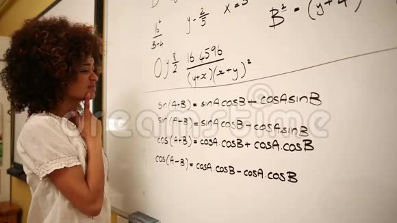 困惑的学生在白板上看数学视频的预览图