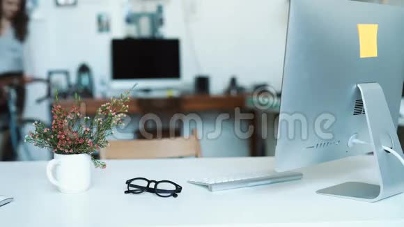 女人一边靠在办公室的桌子边在蓝图上做笔记视频的预览图