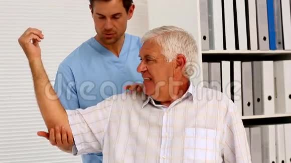 男护士向老年病人展示如何锻炼手臂视频的预览图