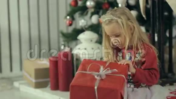 令人惊讶的小女孩坐在她的礼物附近视频的预览图
