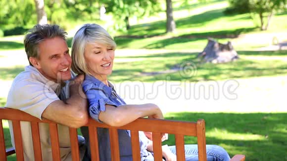 多情的情侣坐在公园的长椅上聊天视频的预览图