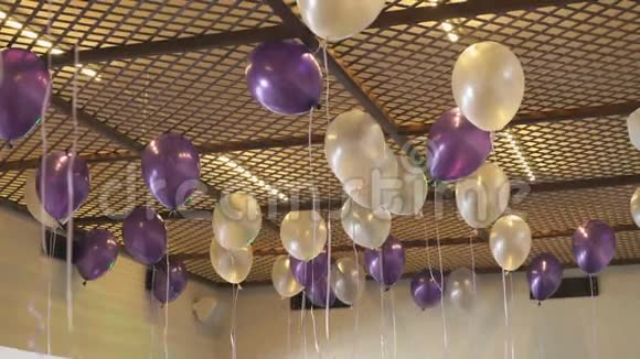 漂浮在天花板上的白色和紫色气球视频的预览图