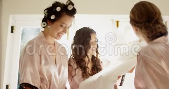 身着睡衣的新娘们为婚纱高兴视频的预览图
