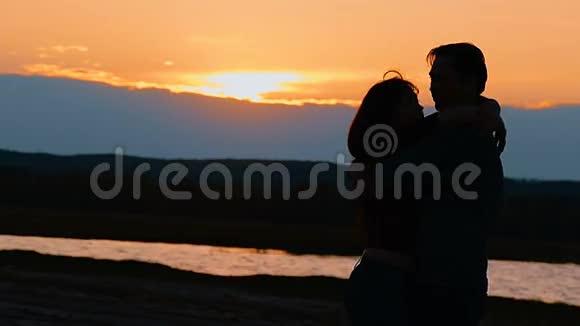 在湖边背景下拥抱女人和男人的慢动作视频视频的预览图