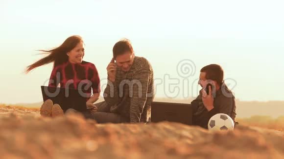 在沙滩上坐着和三个拿着笔记本电脑的人聊天视频的预览图