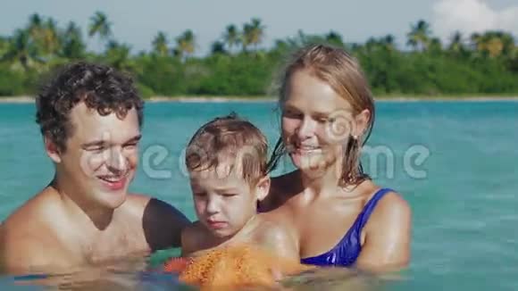 在海水中养海星的父母和儿子视频的预览图